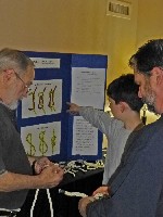 David Hinkins (left) explains knot tying at NVSPS Hospitality Suite, Spring Conference, 4-12-2013 (675x900, 122kb)